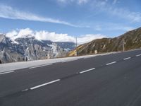 an empty highway is shown on the side of the road near mountains and telephone poles