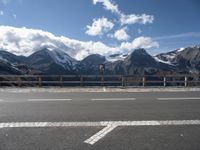 a view of the snow - capped mountains of a mountain range from a highway with a traffic sign