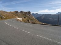 a person on a motorcycle driving on a paved road in the mountains with a mountain view