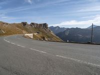 a person on a motorcycle driving on a paved road in the mountains with a mountain view