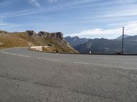 a person on a motorcycle driving on a paved road in the mountains with a mountain view