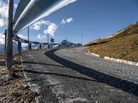 a curve road running in the middle of nowhere on the side of the mountain is a curved metal pipe