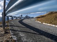 a curve road running in the middle of nowhere on the side of the mountain is a curved metal pipe