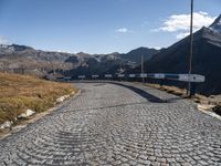 the stone road leading through mountains and valleys with benches on them that are placed near the end