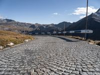 the stone road leading through mountains and valleys with benches on them that are placed near the end