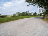 a road going through a field that has no grass and a stop sign on it