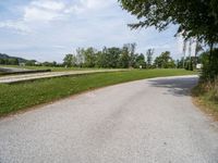 a road going through a field that has no grass and a stop sign on it