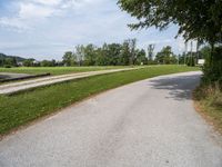 a road going through a field that has no grass and a stop sign on it