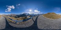 two fisheye shots show the view from across the street in front of mountains, and the sun shining down on the mountain range