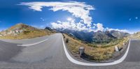 view of a winding road from an 360 - view point of view showing snow capped mountains