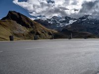 an asphalt road with mountain tops and a white van parked at the curb in front