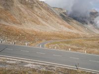 a car drives down a deserted road by a mountain fire hydrant in the distance