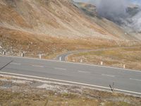 a car drives down a deserted road by a mountain fire hydrant in the distance