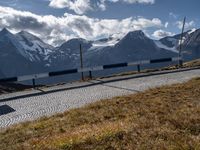 the motorcycle is travelling along the road near some mountains that surround it, in the background, on a path