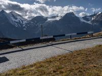 the motorcycle is travelling along the road near some mountains that surround it, in the background, on a path