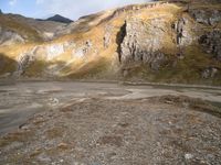 a person that is standing in the dirt with a motorcycle and backpack on a mountain slope