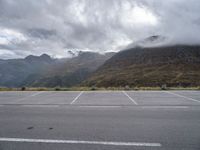 a view of a highway with an empty road on it with mountains in the background