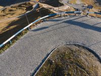 the skateboarder in yellow is riding a long trail of concrete path through a field