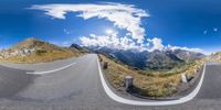 view of a winding road from an 360 - view point of view showing snow capped mountains