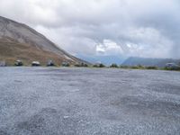 a motorcycle parked in a deserted parking lot on a mountain side with a few clouds