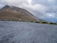 a skateboard is sitting on the concrete in front of a mountain range of rocks