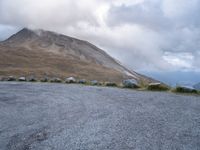 a skateboard is sitting on the concrete in front of a mountain range of rocks