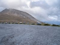 a skateboard is sitting on the concrete in front of a mountain range of rocks