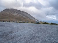 a skateboard is sitting on the concrete in front of a mountain range of rocks