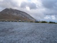 a skateboard is sitting on the concrete in front of a mountain range of rocks