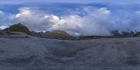 the mountains are covered in clouds and blue skies with fluffy white clouds over them,