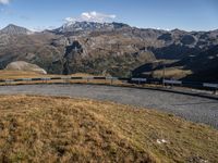 view of mountains with a paved roadway running alongside the road to it and a couple of benches on the side