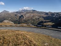 view of mountains with a paved roadway running alongside the road to it and a couple of benches on the side