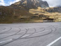 a motorcycle is parked on the empty asphalted road, in front of the mountain