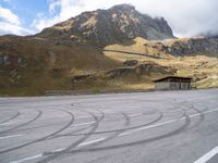 a motorcycle is parked on the empty asphalted road, in front of the mountain