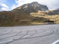 a motorcycle is parked on the empty asphalted road, in front of the mountain