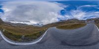 a 360 - eye view of a long curve in the middle of the mountain road