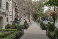 the sidewalk is lined with small bushes and shrubs to make the city look beautiful in autumn
