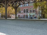 the old building has graffiti on it along the street in front of it, as if to keep from going through it