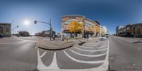 360 degree view of an empty street with cars passing through it in the background and people on the sidewalk