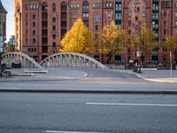 a bridge with an arched arch over a street in a city center under a sun light