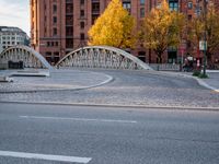 a bridge with an arched arch over a street in a city center under a sun light