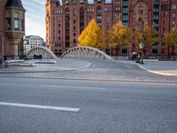 a bridge with an arched arch over a street in a city center under a sun light