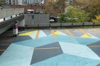 a parking garage has an unusual painted mural on it's surface, outside of a building