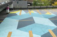 a parking garage has an unusual painted mural on it's surface, outside of a building