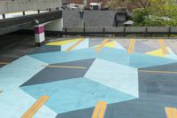 a parking garage has an unusual painted mural on it's surface, outside of a building