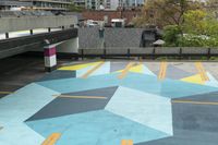 a parking garage has an unusual painted mural on it's surface, outside of a building