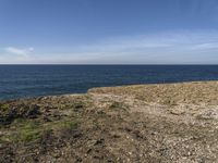 there is a blue sky that can be seen in the distance above the water and land