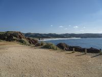 a gravel field with a beach on one side and mountains in the back ground to the other