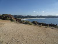 a gravel field with a beach on one side and mountains in the back ground to the other