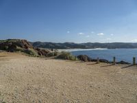 a gravel field with a beach on one side and mountains in the back ground to the other